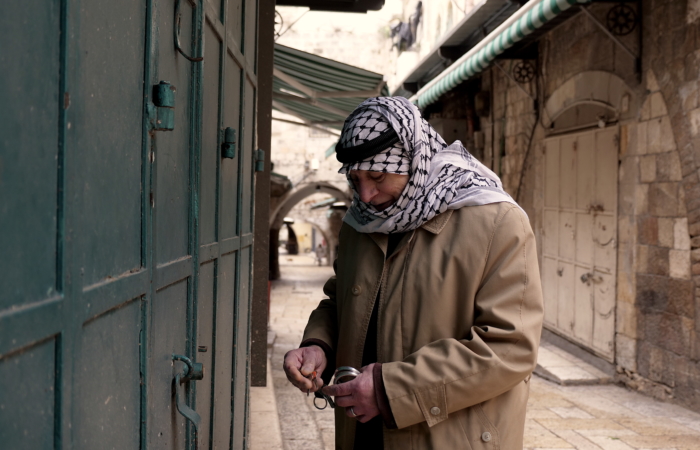 Un vendeur du souq ferme sa boutique après avoir reçu les annonces de confinement obligatoire. ©Claire Riobé/TSM