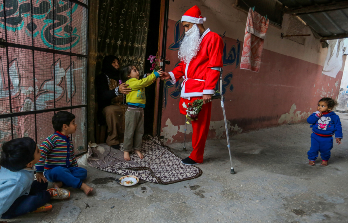 Un Palestinien déguisé en Père Noël distribue des fleurs dans le camps de réfugiés de Khan Yunis au sud de la bande de Gaza, le 24 décembre 2020. Abed Rahim Khatib/Flash90 