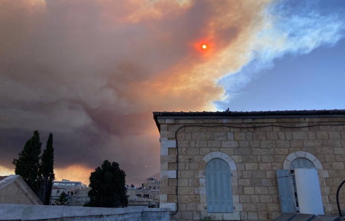 Masqué par un épais nuage ocre, le soleil rougeoie au dessus de Jérusalem ©Beatrice Guarrera