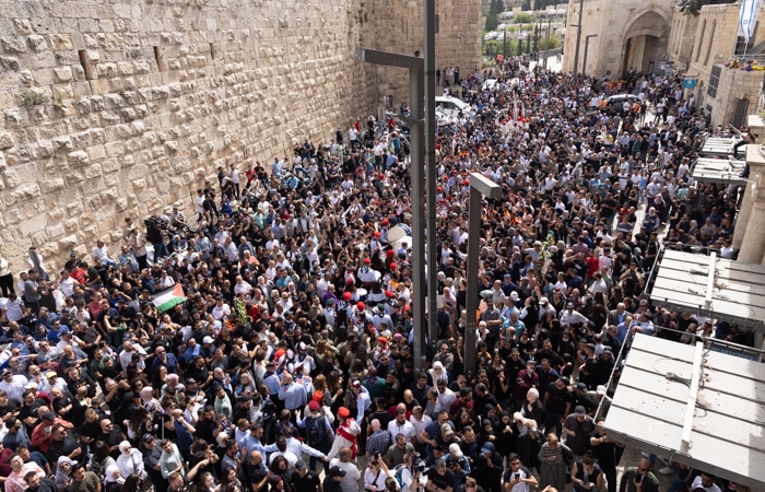 Les scouts traversent la foule massée porte de Jaffa de la Vieille ville de Jérusalem. devançant le cortège qui prend la direction du cimetìère où doit être inhumée Shireen Abu Akleh.