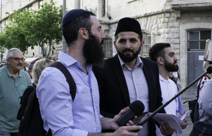 Imad Masri, imam de la communauté musulmane messianique de Haïfa, et Zevi Slavin, juif hassidique discutent dans le cortège ©Cécile Lemoine/TSM